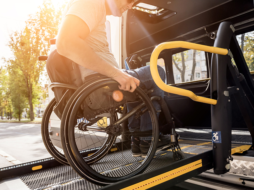 A Man in a Wheelchair Getting on a Mobility Van | Mobility Aids and Equipment