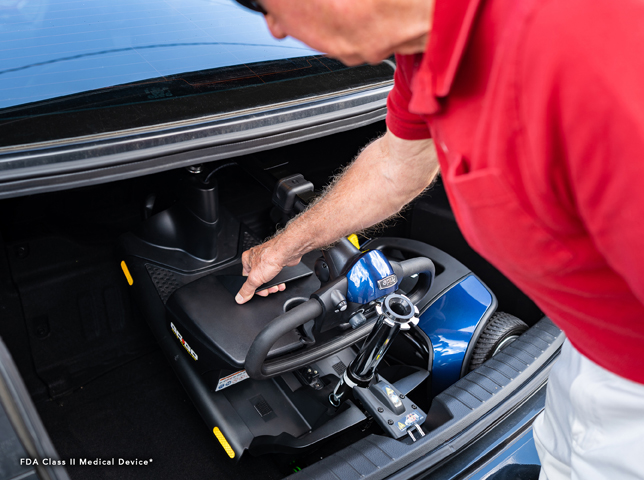 Man in Red Putting Folded Scooter in the Trunk | Mobility Service Provider