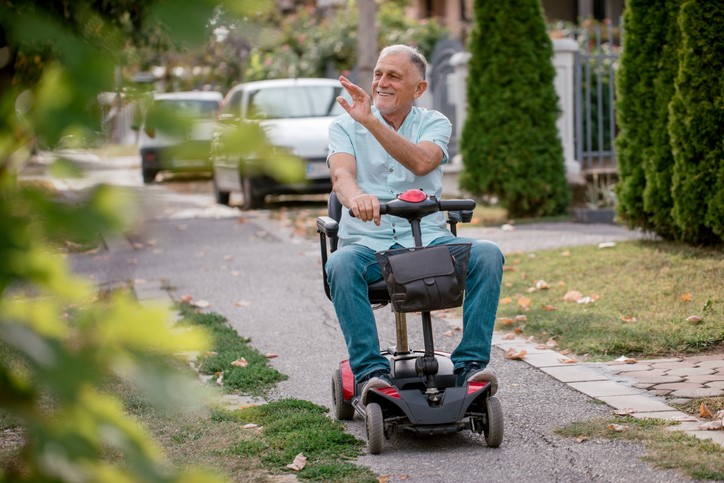 A Man in Mobility Scooter Waving | Innovative Mobility Aid